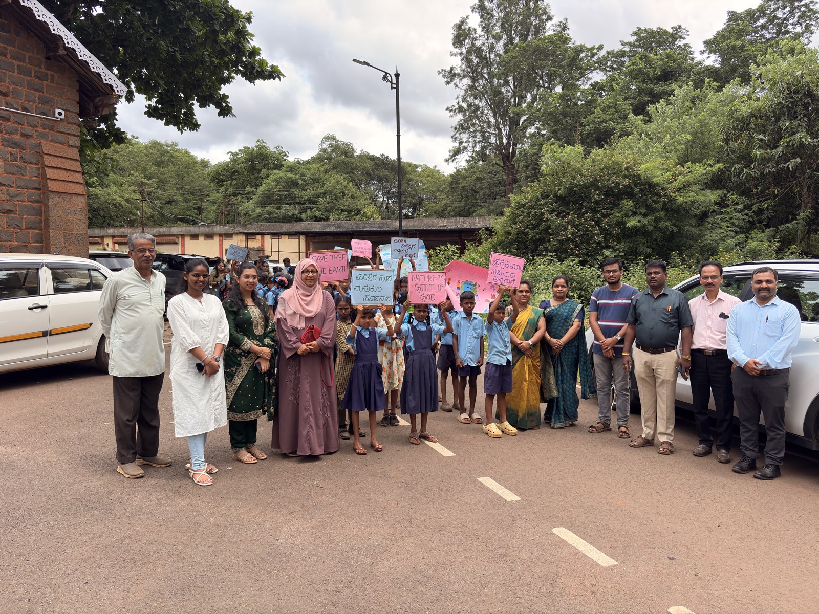 Students from Government High School, Rani Channamma Nagar, Belagavi, with Tejomarg Foundation members and dignitaries holding hand-made environmental awareness placards at the Vaccine Depot.